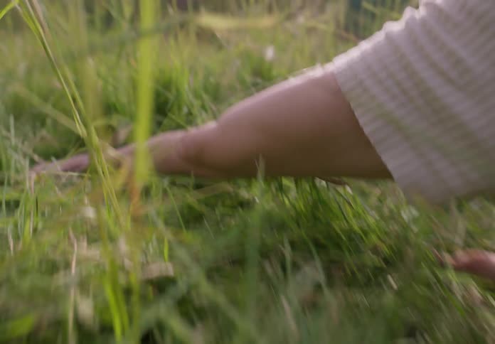A woman dances sadly in a meadow during the day
