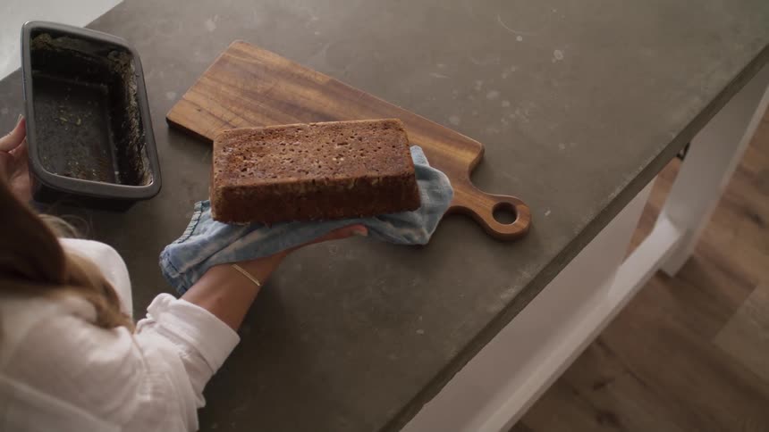 A woman flip a food from a plastic plate and place it in a cutting board