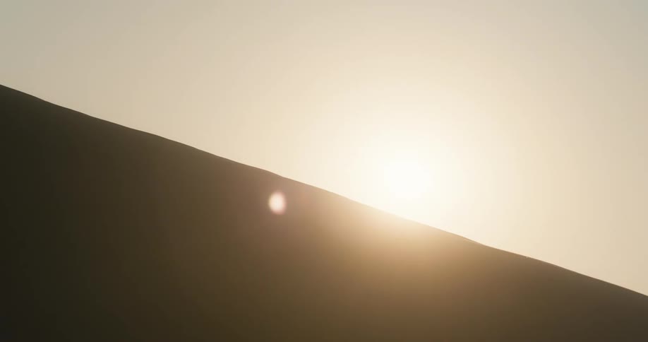 The sun behind a sand dune in the desert