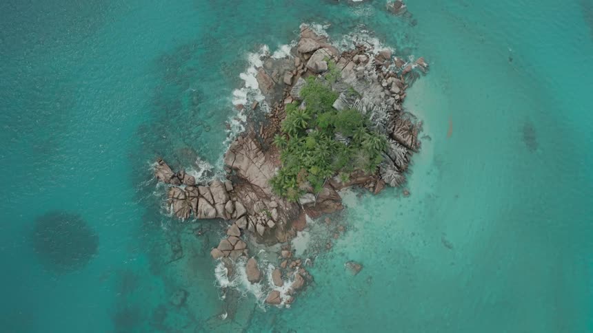 Top view of a small island in a crystal blue sea
