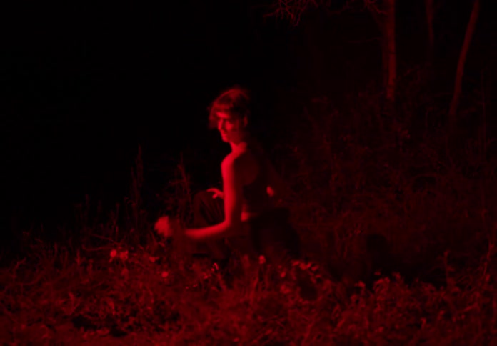 A red light flashes on a dancing woman