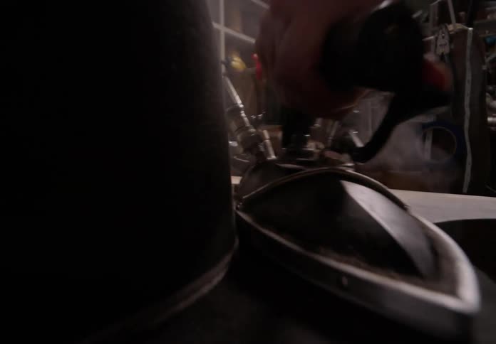Closeup of a persons hand ironing an industrial black hat