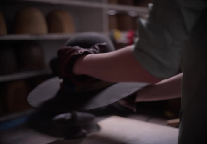 A milliner manufacturing hats in his workshop