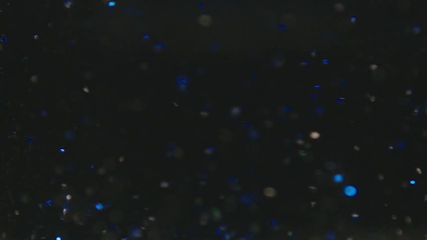 Water swirling with blue glimmers in slow motion