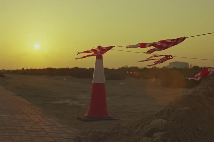 View of a cone in the sand in an area with a sunset horizon