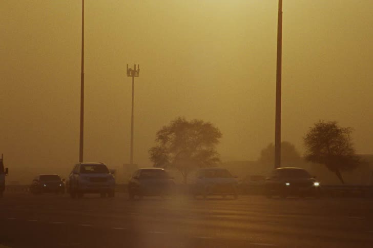 Moving vehicles on a city road at sunset