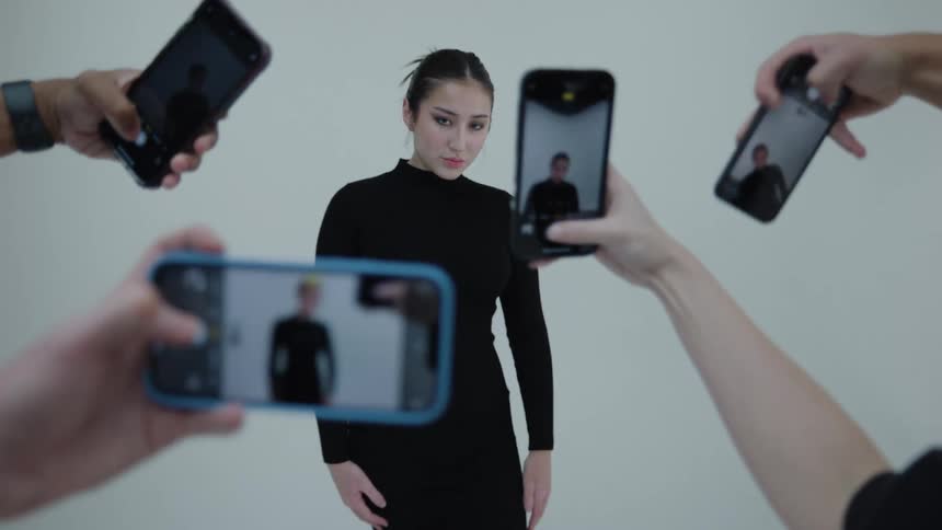 People taking pictures of a female model with mobile phones