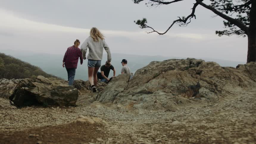 Friends on top of a mountain on a cloudy day
