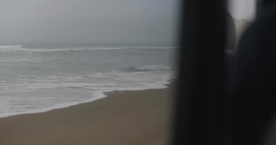 Shoreline on the coast next to the ocean seen from a moving vehicle