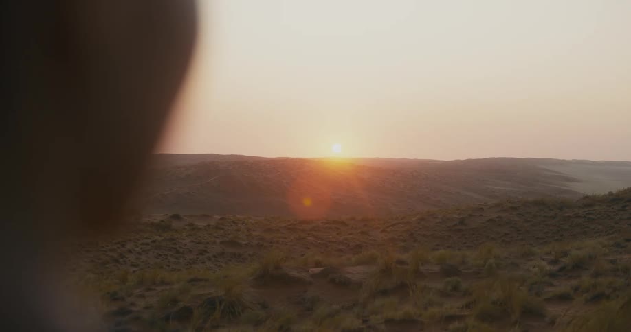 View of a landscape with mountains and the sun rising on the horizon
