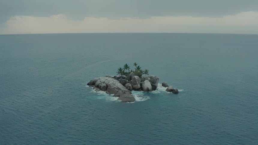 Aerial of a remote rocky island in the ocean on a cloudy day