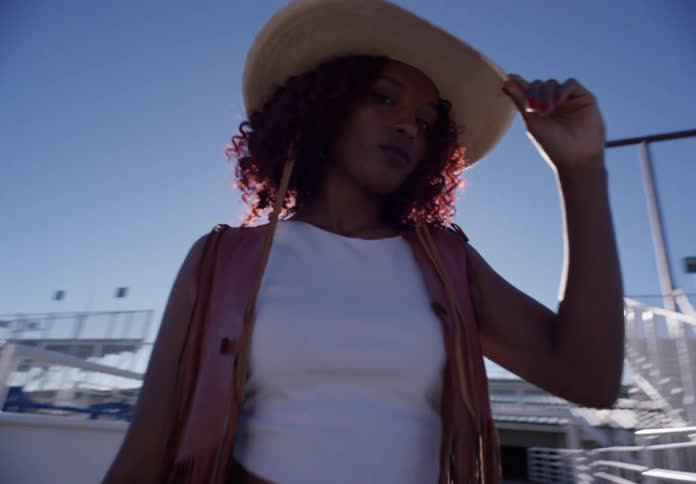 A woman is standing in the rodeo arena
