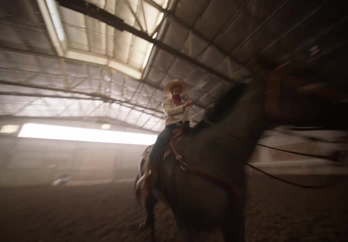 Cowboy rides a horse inside a hangar