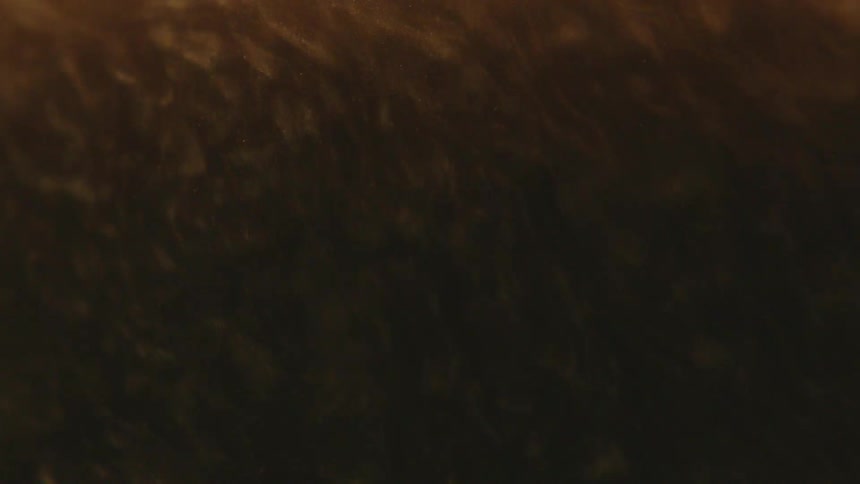 Dense brown abstract liquid in slow motion