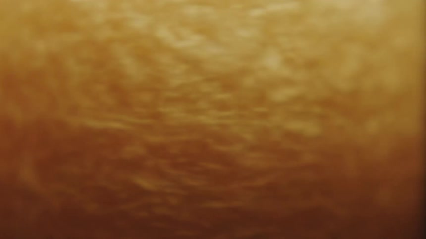 Golden and abstract liquid spiraling in slow motion