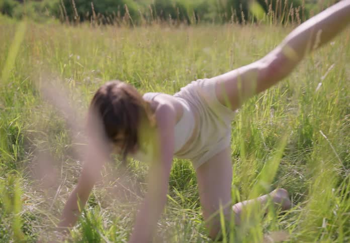 Woman dancing in the midst of bushes in a natural environment
