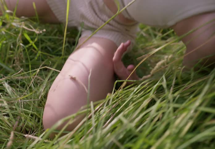 A woman is twisting her body around in the grass