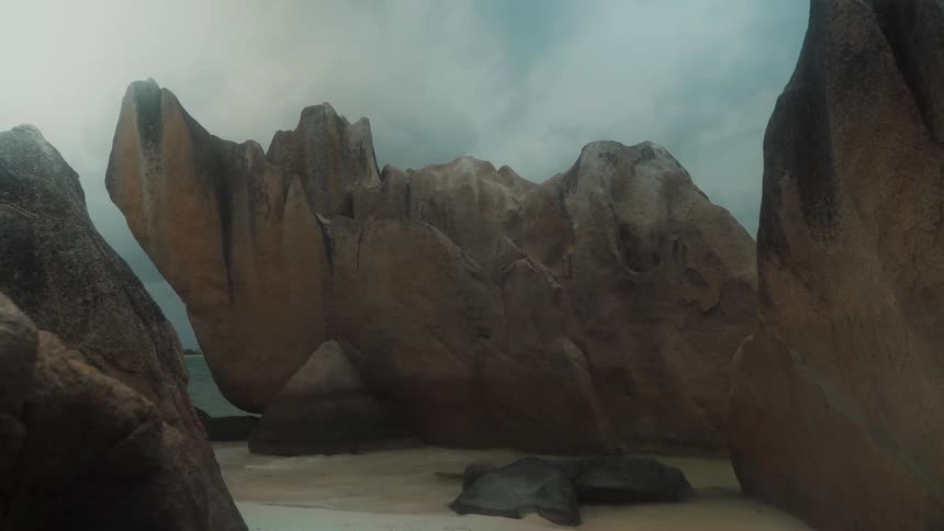 Rocky stones on the sandy beach next to the sea on a cloudy day