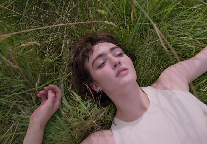 Portrait of a young woman lying among the foliage of nature