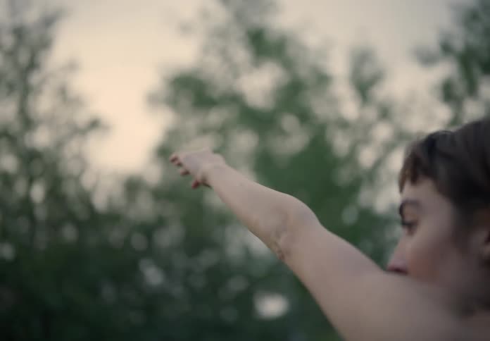 Woman dancing with her back turned in a field in nature
