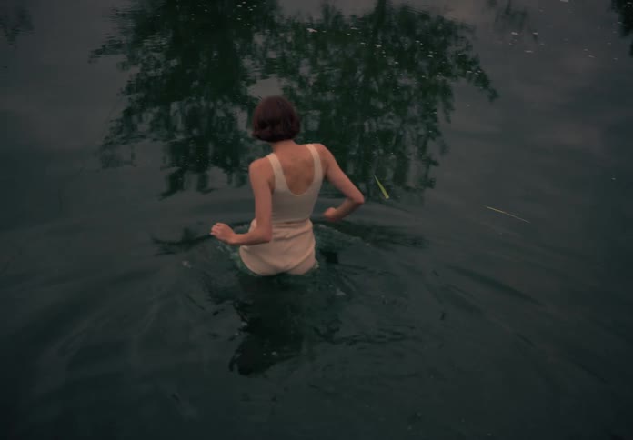 Woman walks into a lake