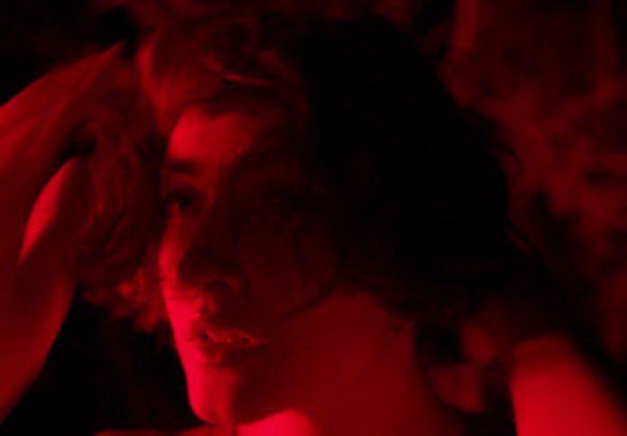 Portrait of a young woman in the forest with a reflection of red light on her face