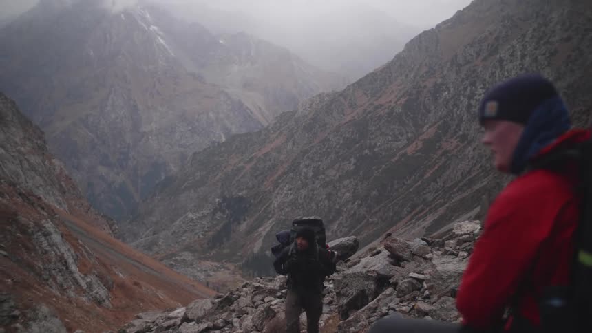 Friends climbing a rocky mountain on a cold day