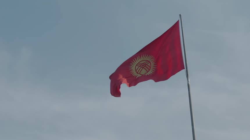A red flag fluttering waving against the wind