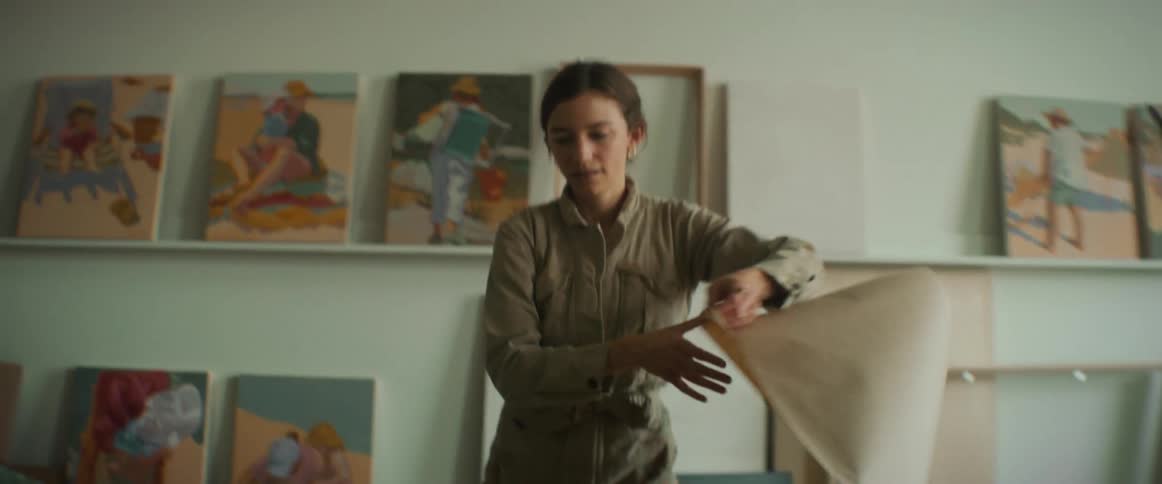 Woman wrapping a painting on top of the table