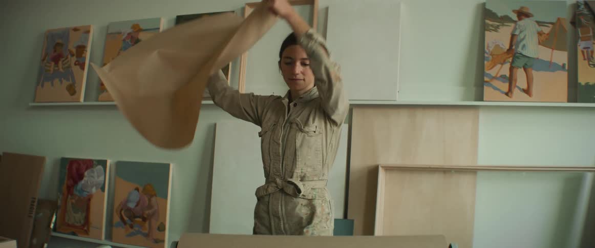 Woman using both hands to pick up a piece of wrapping paper