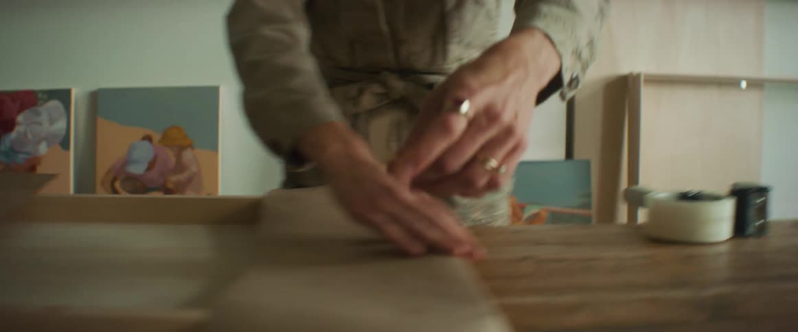 Closeup of a womans hands taping a frame package