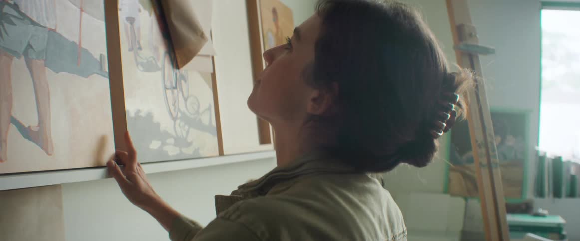 Happy artist places a painting on a shelf