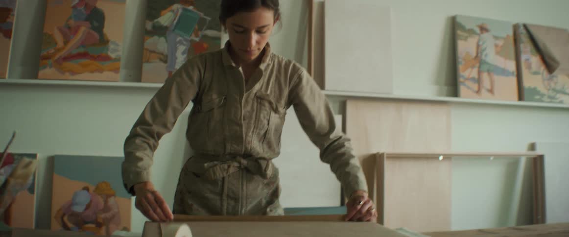 A woman folding and cutting sheets of brown paper