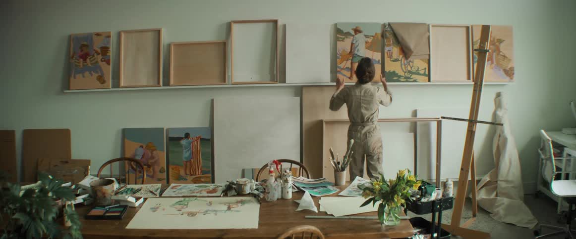 Artist places a finished painting on a shelve