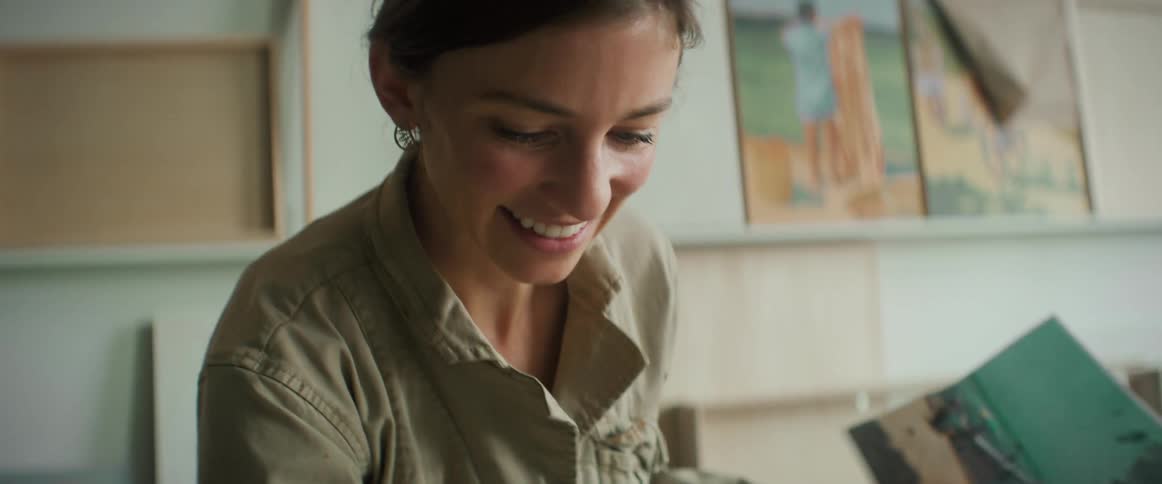 A woman is painting on the canvas