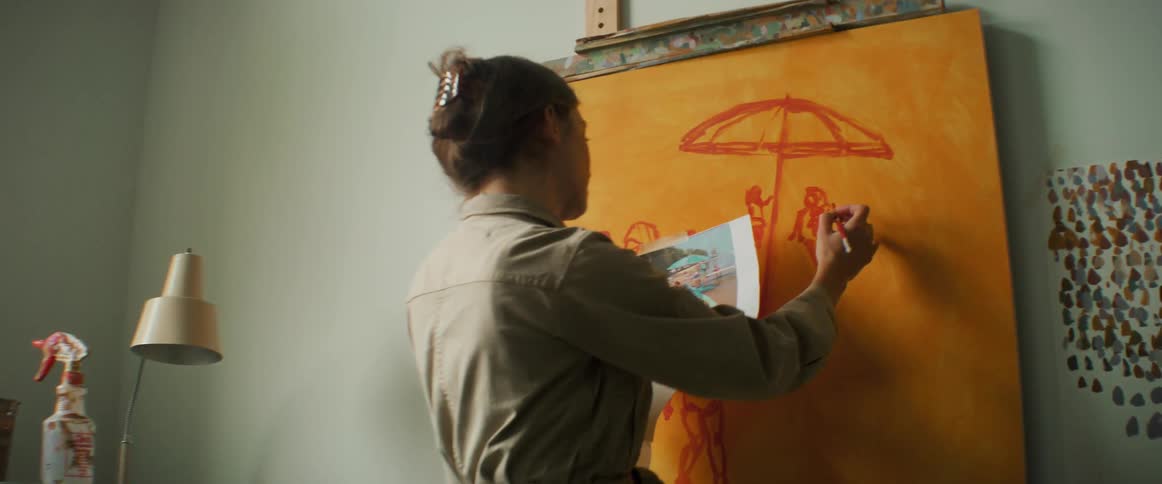 A woman is painting on the canvas