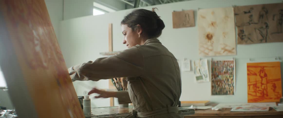 Artist painting on canvas in her studio