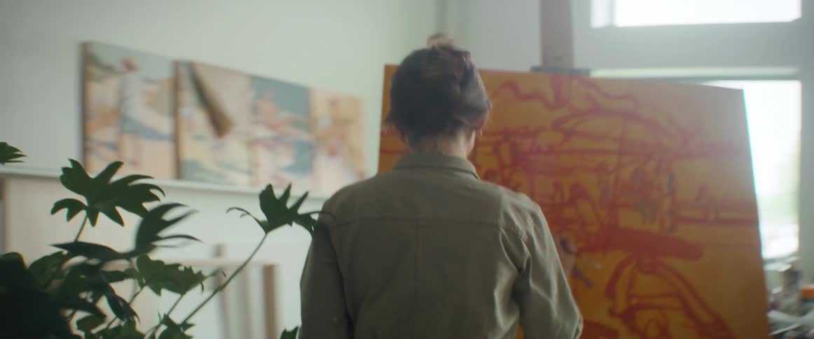 Orbiting view of an artist painting in canvas