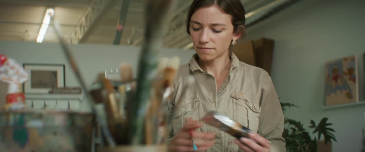 Woman painting a canvas on a table