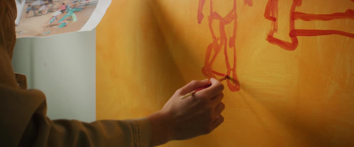 Woman standing in front of a canvas painting a picture