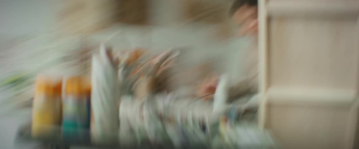 A time lapse shows a female painter working on a large canvas