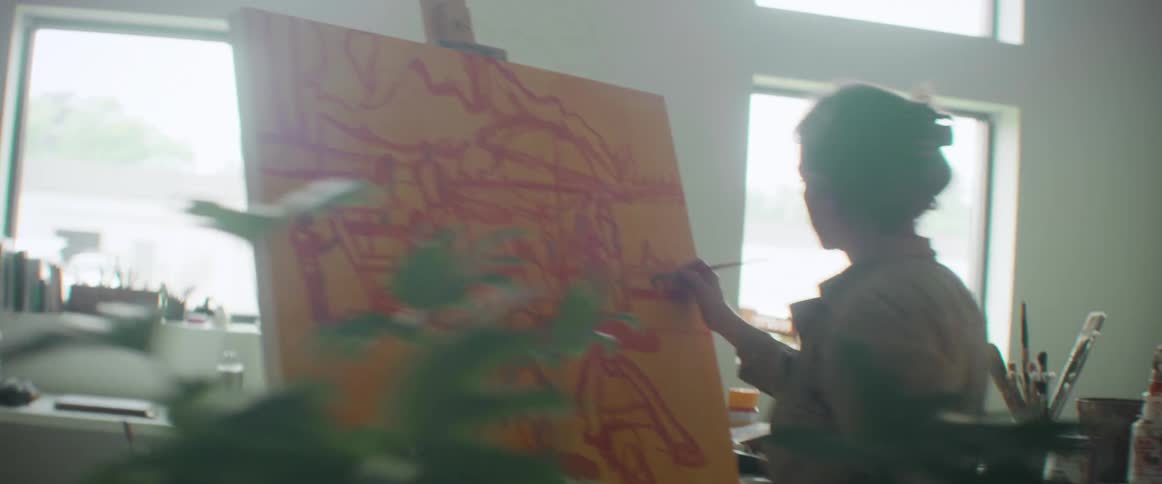 Orbiting view of an artist painting in canvas