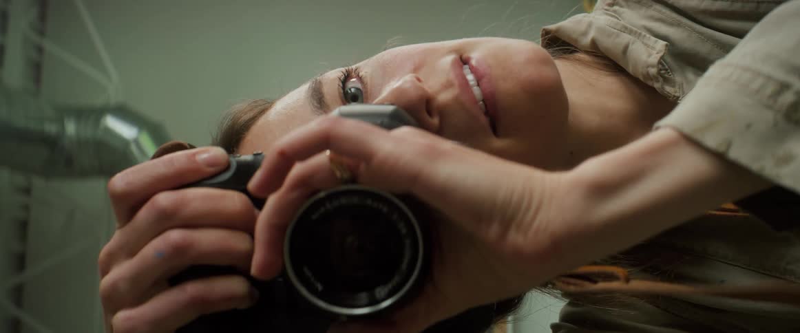 Closeup of a womans face taking a photo with a professional camera