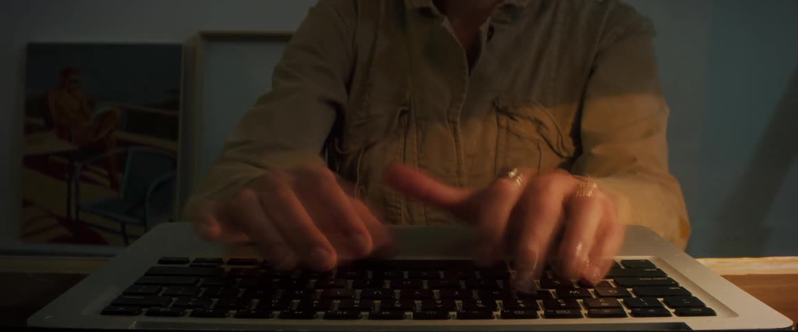 Time lapse of a woman typing on a laptop keyboard day to night