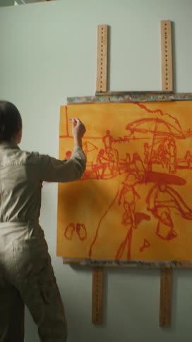 A woman is painting on the canvas