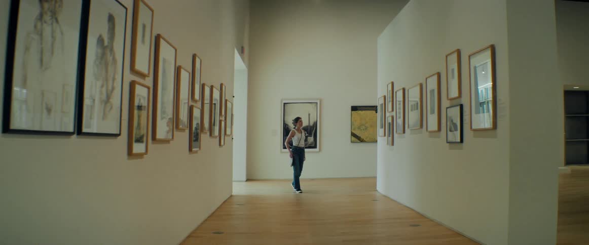 A woman looking at paintings in an art gallery