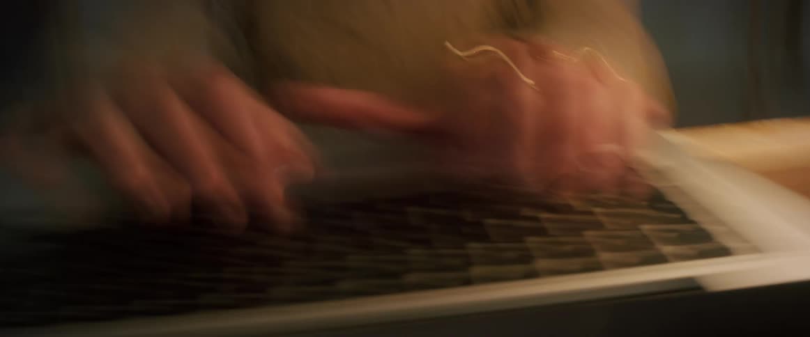 Closeup of a womans fingers typing on a laptop