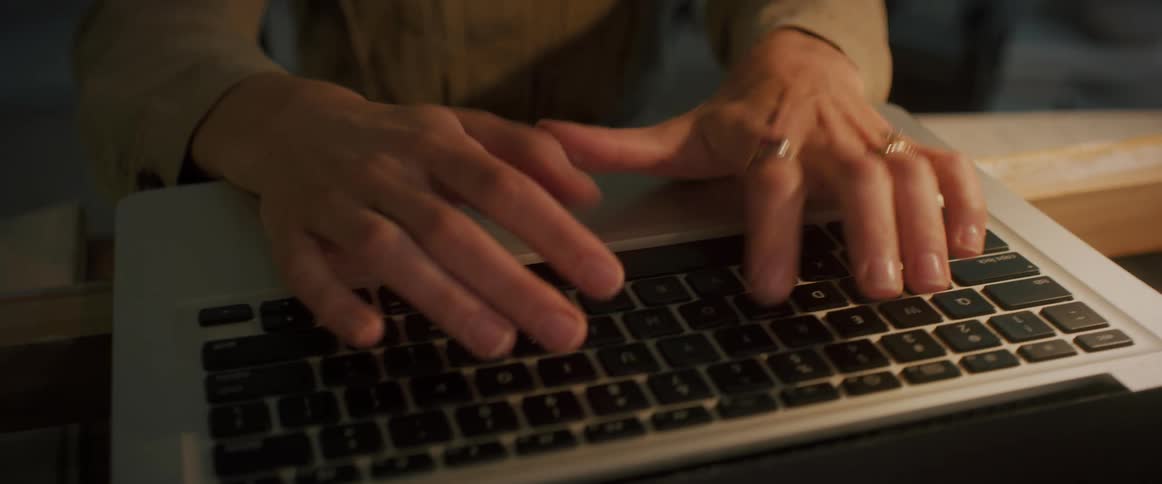 A woman is typing on her laptop