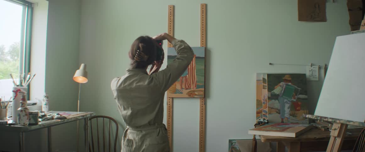 Artist taking pictures of a painting in her studio