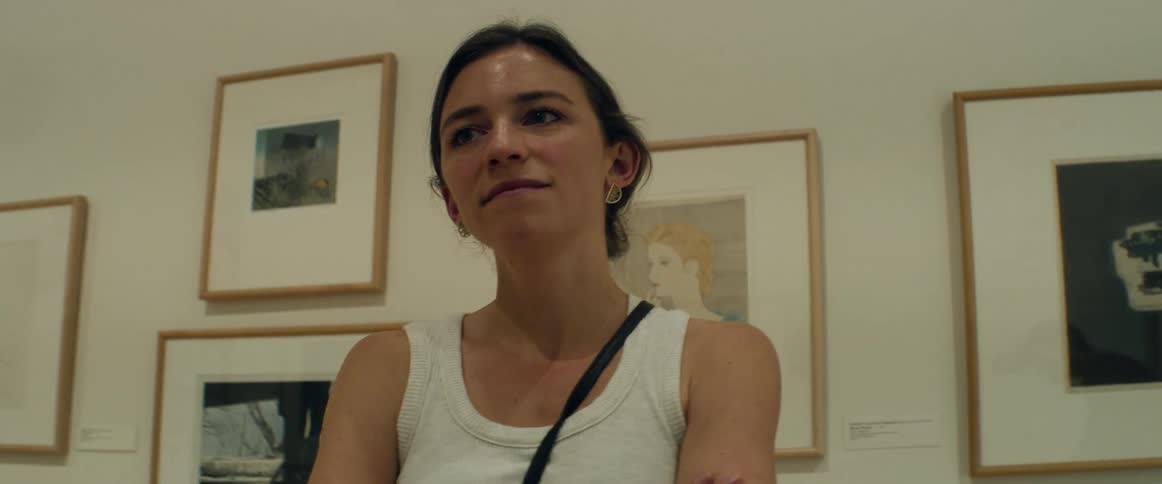 Young woman looking at paintings in a museum